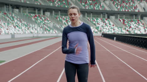 Porträt-Einer-Kaukasischen-Frau,-Die-Sich-Vor-Einem-Lauf-Am-Frühen-Morgen-Auf-Einer-Leeren-Stadionstrecke-Aufwärmt.-Aufgenommen-Mit-Einem-Anamorphotischen-Objektiv